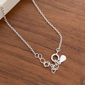 Macro shot of S925 sterling silver chain with spring clasp and hallmark tag on wood