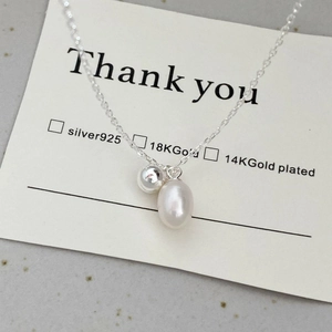 Detailed macro of a S925 silver double pendant necklace with a natural freshwater pearl