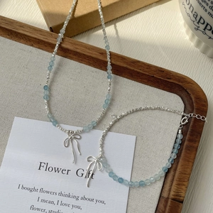 Close-up of S925 silver beaded jewelry set with blue gems and a bow pendant