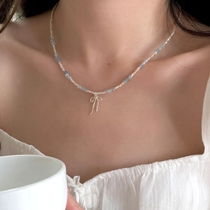S925 silver beaded necklace with aquamarine stones and a bow pendant on model