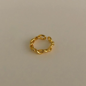 Detail of minimalist gold twisted rope ring featuring an adjustable open band design