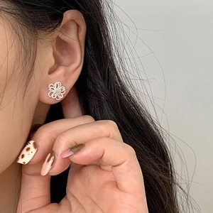 Elegante S925 Sterling Silber Hohlblumen Ohrstecker an einem Modell in Nahaufnahme