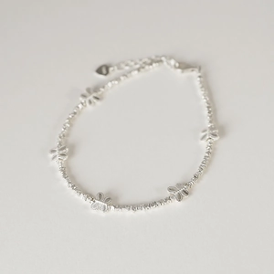 Detail view of S925 sterling silver bow bracelet with silver beads and heart tag charm