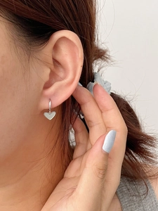 Close-up of heart-shaped S925 silver earring worn by a model in a minimalist style