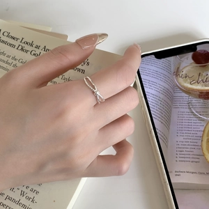 Close-up of minimalist S925 sterling silver twisted knot ring worn on the finger