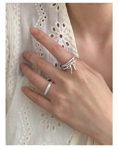Detail of S925 sterling silver ribbon bow and eternity pavé diamond ring set on hand
