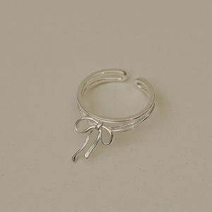 Close-up of S925 silver ribbon bow ring featuring a dual parallel band and open design