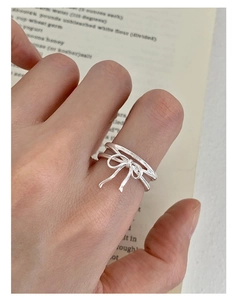 Macro shot of S925 silver double-layered ribbon bow ring on finger with adjustable band