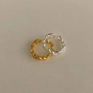 Detail shot of twisted rope adjustable rings in polished gold and silver finishes