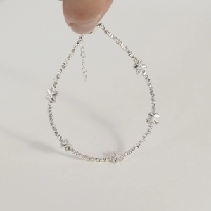 Close-up of S925 silver beaded bracelet featuring five hollow butterfly charms and lobster clasp