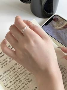 Close-up of S925 sterling silver twisted knot ring worn in a cozy lifestyle setting