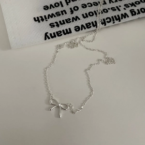 Detailaufnahme einer minimalistischen S925 Silber Schleife Halskette auf weißem Grund