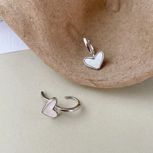 Detailed macro view of S925 silver heart earrings with white mother of pearl inlay