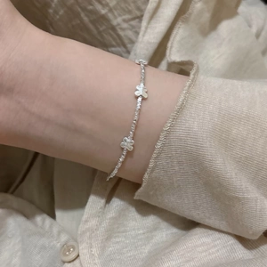 Close-up of S925 sterling silver bow bracelet with textured beads on woman's wrist
