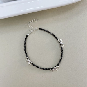 Détail du bracelet en argent S925 avec perles de spinelle noire et breloques en noeud