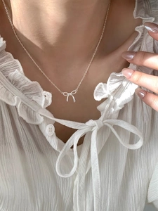 Nahaufnahme der eleganten S925 Sterling Silber Schleife Halskette am Hals getragen