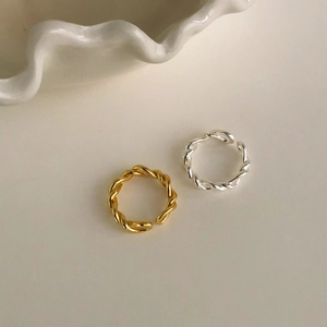 Detailed close-up of twisted rope texture on silver and gold minimalist rings