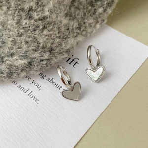 Detailed view of S925 silver heart hoop earrings with mother of pearl inlay on poem card