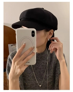 Detailed view of S925 silver chain tassel earring worn with a stylish black baker boy cap