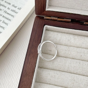 Detail shot of a twisted 925 sterling silver ring in a luxury wooden jewelry box