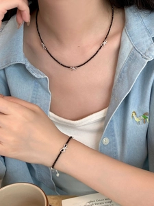 Modèle portant un ensemble collier et bracelet nœud en argent S925 avec perles spinelle