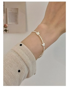Detailed view of an S925 sterling silver beaded bracelet with delicate butterfly charms