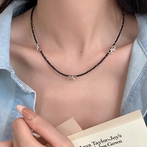 Détail d'un collier en spinelle noire avec des pendentifs noeuds porté par un mannequin
