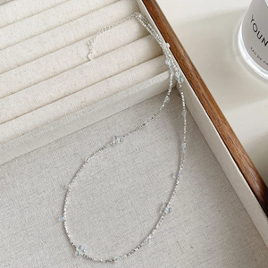 Détail d'une chaîne en argent S925 avec perles irisées et breloque en cœur