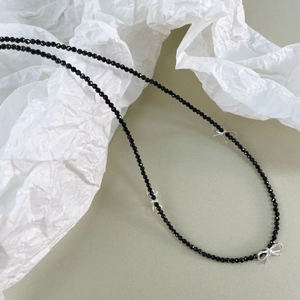 Détail des nœuds en argent S925 sur collier de perles en spinelle noire facettée