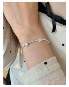 Close-up of S925 sterling silver bow bracelet on model wrist with sweet aesthetic style