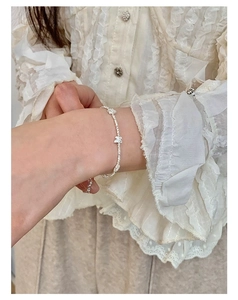 Detail view of S925 silver bow bracelet with sparkling crystals on a female wrist