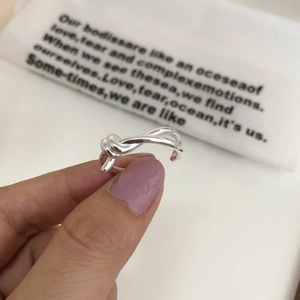 Close-up of S925 sterling silver knotted ring with adjustable open design on finger