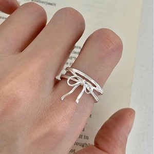 Elegant S925 sterling silver ribbon bow ring with double band design on a model's hand