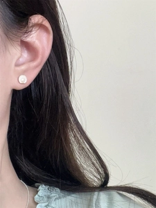 Close-up of minimalist S925 silver shell stud earring with freshwater pearl on ear