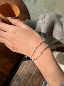 Close-up of stacked S925 sterling silver woven twist bracelets with shiny round beads