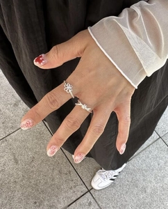Close-up of minimalist S925 silver knot rings set on finger with stylish outdoor background