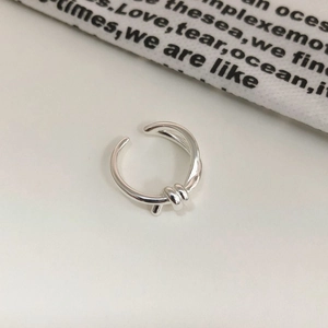 Close-up of minimalist S925 silver knot ring featuring a delicate open design
