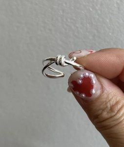 Detail of S925 sterling silver knot ring featuring a minimalist double-line entwined design
