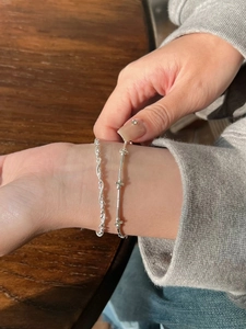 Detail of S925 sterling silver layered bracelet with braided design and small silver beads