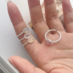 Detail of four S925 silver rings with oval moonstone and quartz in woven texture