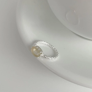 Detailed macro of a woven S925 silver ring featuring an oval yellow crystal stone