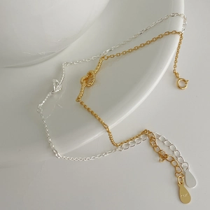 Macro detail of S925 sterling silver stamp on gold and silver twisted knot bracelets