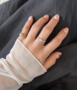 Close-up of S925 sterling silver knotted ring and beaded band set on model hand
