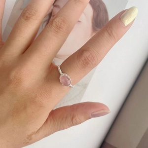 Close-up of S925 silver ring with oval pink rose quartz and textured band on hand