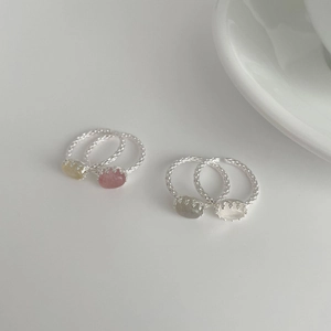 Detailed macro of four S925 silver oval crystal rings with woven texture bands
