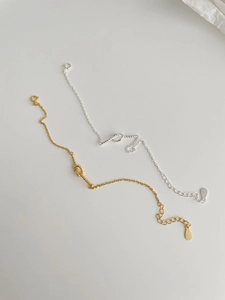 Close-up of gold and silver knot-style s925 silver chain bracelets with lobster clasp