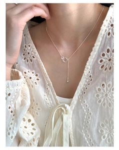 Detail of S925 sterling silver interlocking rings necklace with a dangling silver bead