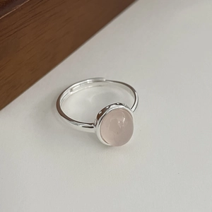 Gros plan du poinçon argent S925 et de la calcédoine rose ovale sur la bague réglable