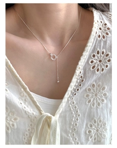 Close-up of interlocking S925 sterling silver rings pendant with zircon and tassel chain