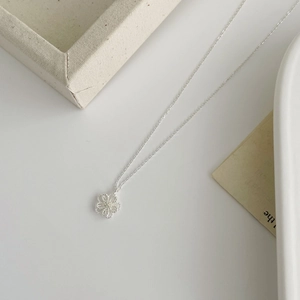 Detailed macro view of S925 silver hollow flower pendant necklace with bead texture edge